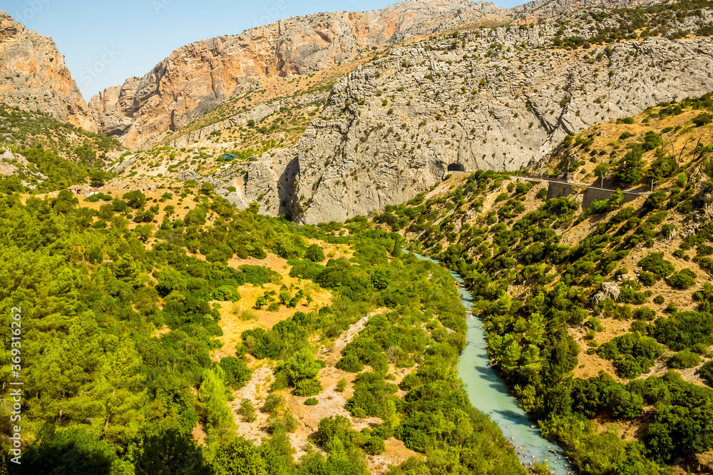 A view from the Caminito del Rey pathway looking back along the wide section of the Gaitanejo river gorge near Ardales, Spain in the summertime