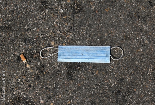 Athens, Greece,  August 1 2020 - Surgical face mask thrown on the ground at the port of Piraeus. © Theastock