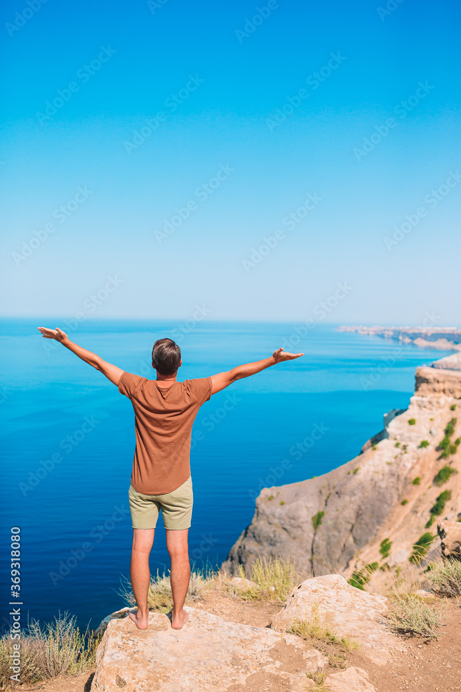 Tourist man outdoor on edge of cliff seashore
