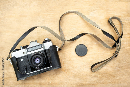 Old retro camera on brown wooden boards abstract background