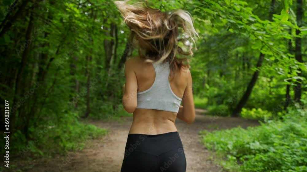 Young sporty woman jogging through the forest Young sporty woman jogging through the forest