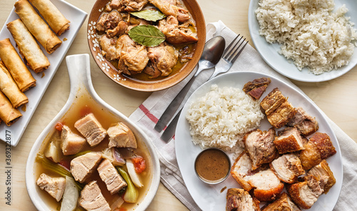 Φωτογραφία filipino dinner with sinigang, lechon kawali, and chicken adobo top down composi