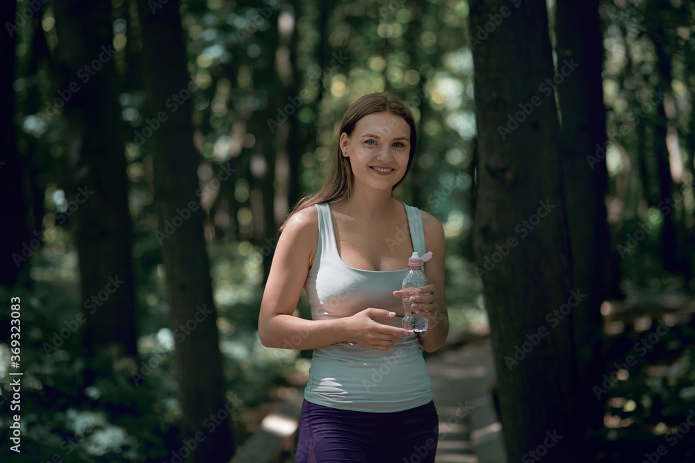 Beautiful young healthy girl goes in for sports in a summer park.