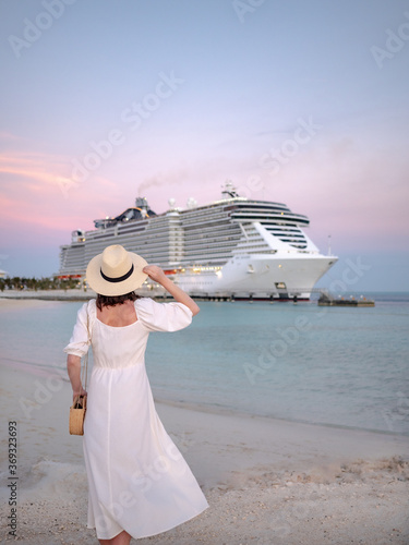 Foto Young woman by the cruise ship at sunset