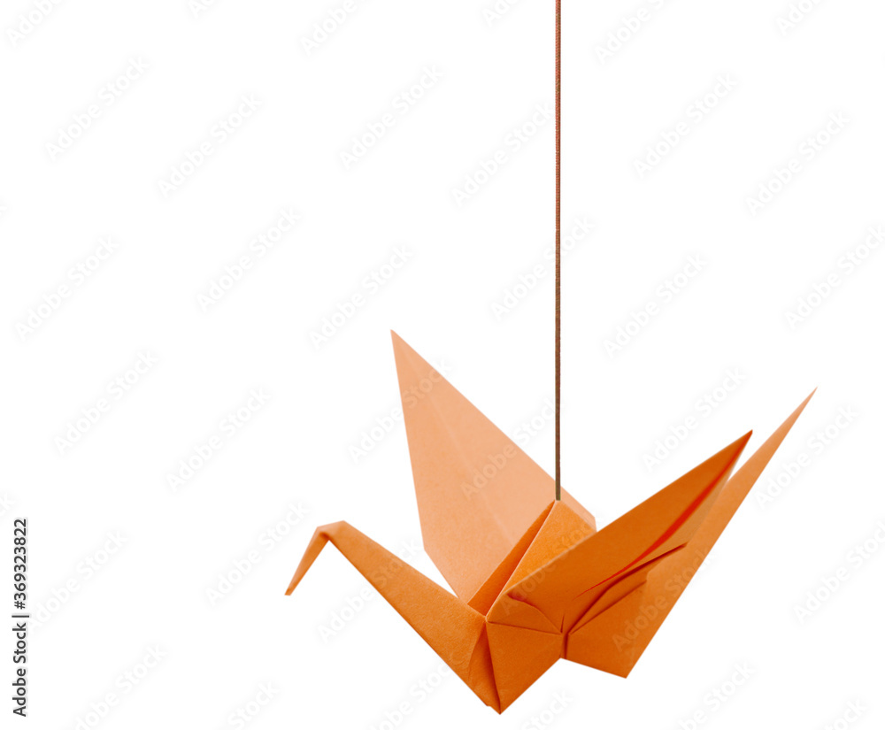 An orange origami paper bird with haning string isolated white An orange origami paper bird with haning string isolated white