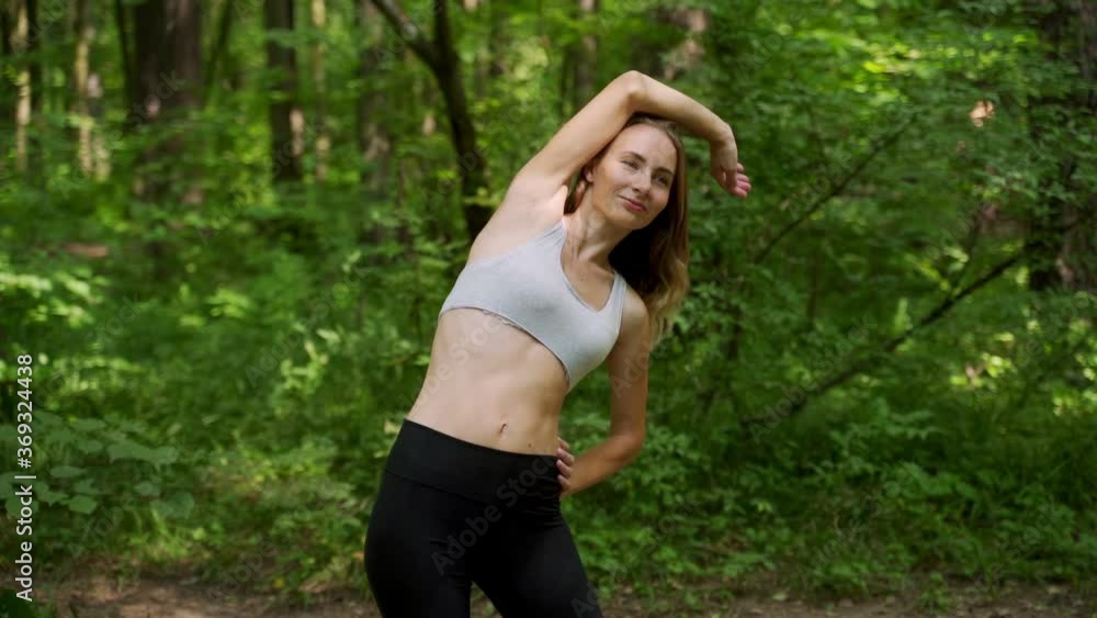 Young woman warms up before a fitness workout in the Park. A healthy young woman is warming up in the open air. Young woman warms up before a fitness workout in the Park. A healthy young woman is warming up in the open air.