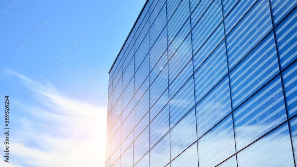 Commercial building close up. Abstract texture of blue glass modern building. Business background. Glass surface with sunlight. Commercial building close up. Abstract texture of blue glass modern building. Business background. Glass surface with sunlight.