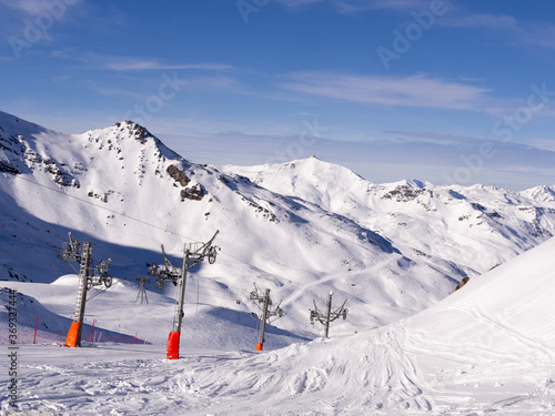 ski track and ski lift in high mountains with snow in the sun © tasslo.studio