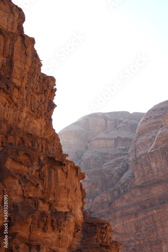 Deserted landscape view of the Wadi Rum desert, close-up of a rock cliff, mountain and dunes, orange and red, Jordan.