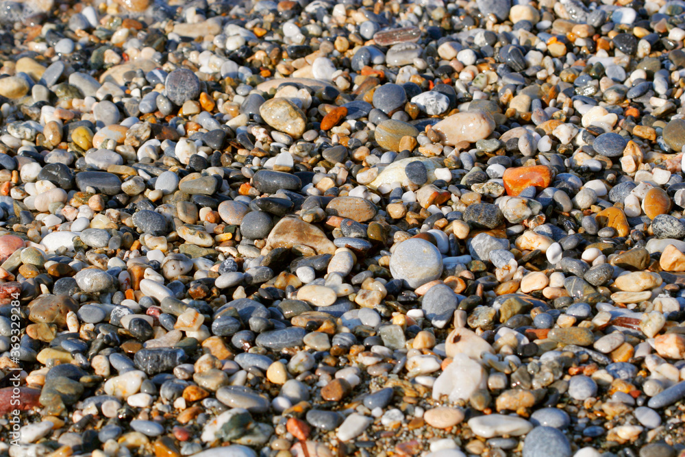 A close up view of smooth polished multicolored stones washed a A close up view of smooth polished multicolored stones washed a
