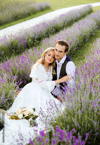 Picnic in a lavender field during sunset. Newlyweds on their wedding day.