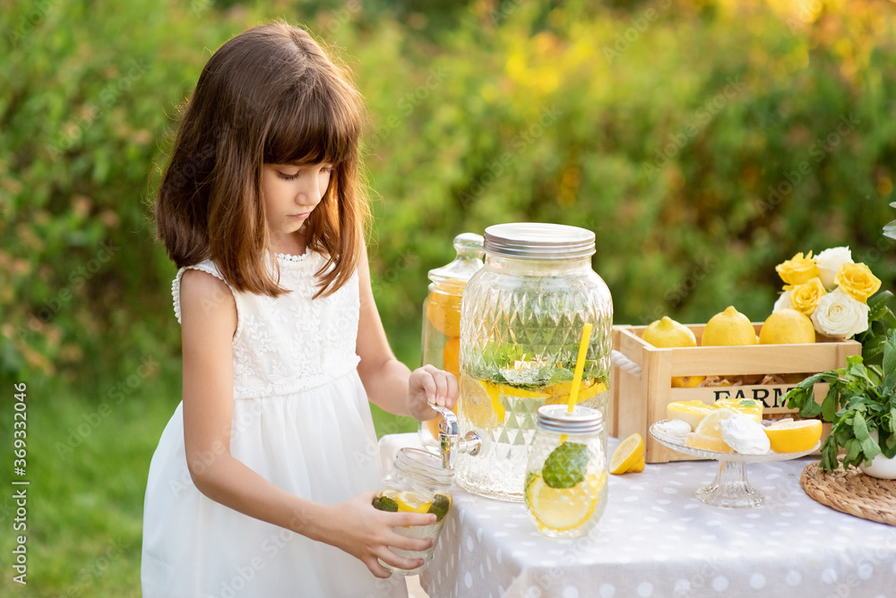 Girl in the summer makes homemade lemonade. Detox fruit infused