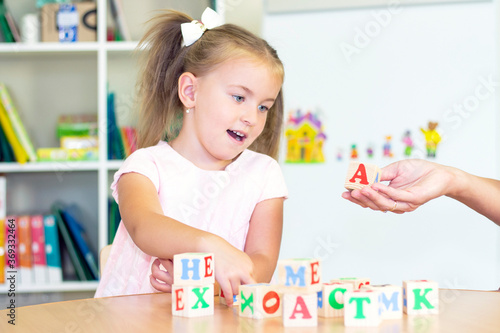 developmental and speech therapy classes with a child-girl. Speech therapy exercises and games with letters. dice game photo