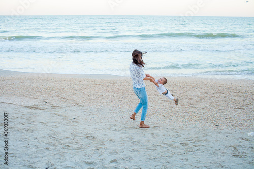 Mother and son playing near sea on seashore