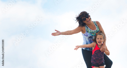 JOYFUL MOM AND DAUGHTER IN THE MOUNTAIN