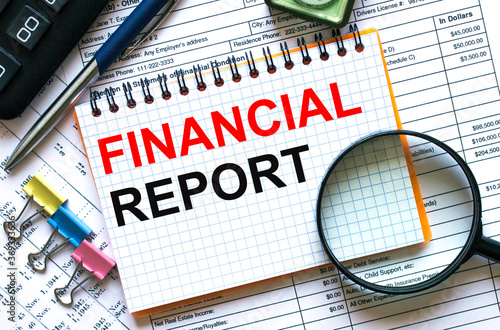 Text Financial Report on notepad with calculator, clips, pen on financial report