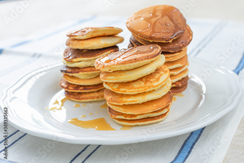 A stack of hot pancakes on a white plate. On Top Of The Honey. Traditional American Breakfast. Close-up, selective focus