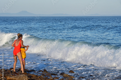 Vladivostok  Russia   July  21  2020. Woman with a child looking for large wave in sea of Japan 