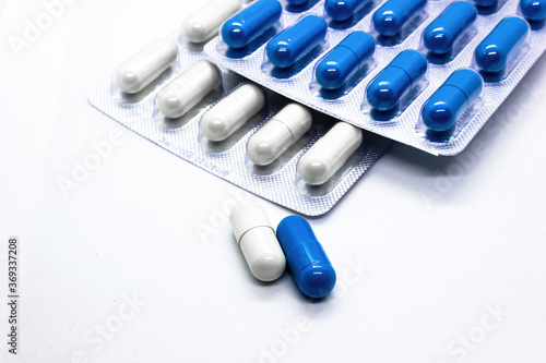 Close up a supplements medicine capsules of white and blue colors against white background