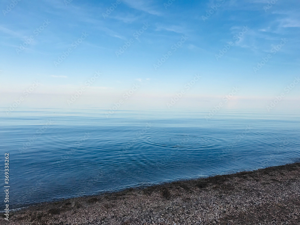 A ripple in the calm water during dusk. A ripple in the calm water during dusk.
