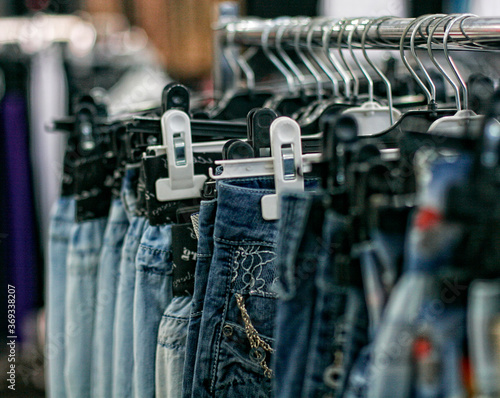 Row of hanged blue jeans in a shop