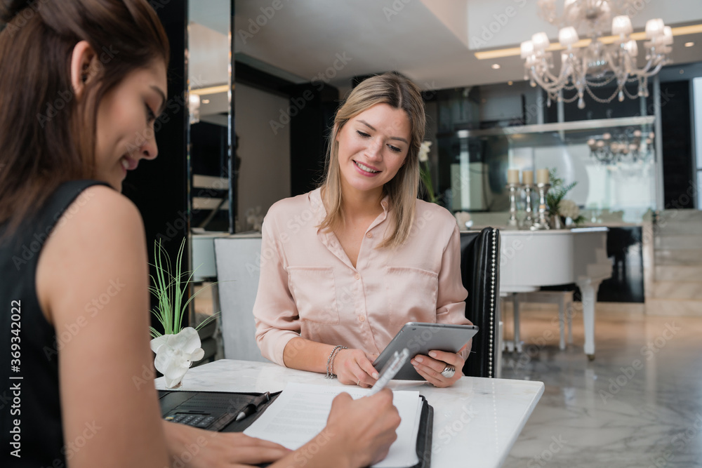 Two businesswomen having meeting at hotel lobby. Two businesswomen having meeting at hotel lobby.