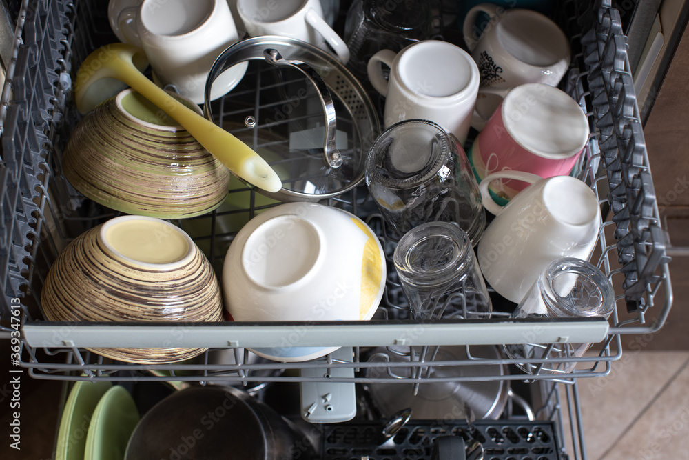 Clean dishes in dishwasher. Freshly washed dishes, plates, cups, jars, mugs, cutlery, pots. Concept of hygiene, household, home care, water saving, technologies and helpers in everyday life