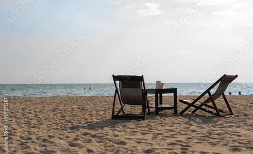 Empty beach lounge chairs in front of the sea, copy space. © 22Imagesstudio