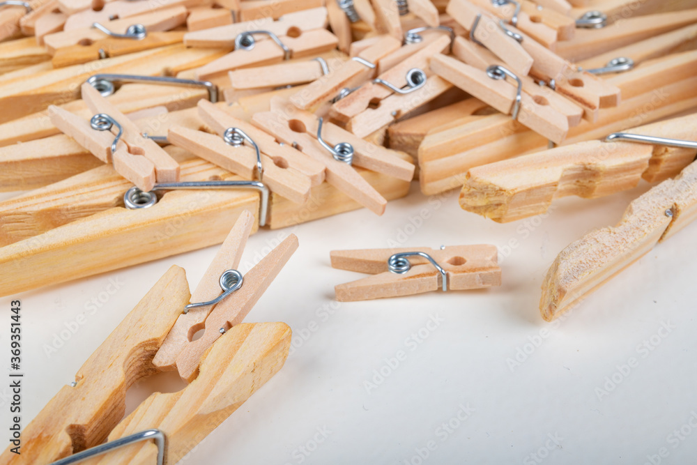 Small and large wooden clothes pegs. Household accessories. White background.