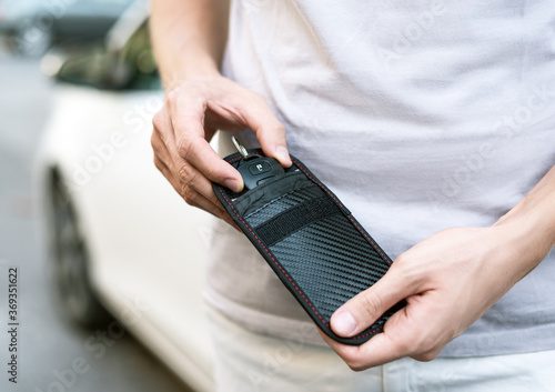 Obraz na płótnie Man using RFID protection pouch for car key, anti-theft RFID key pouch