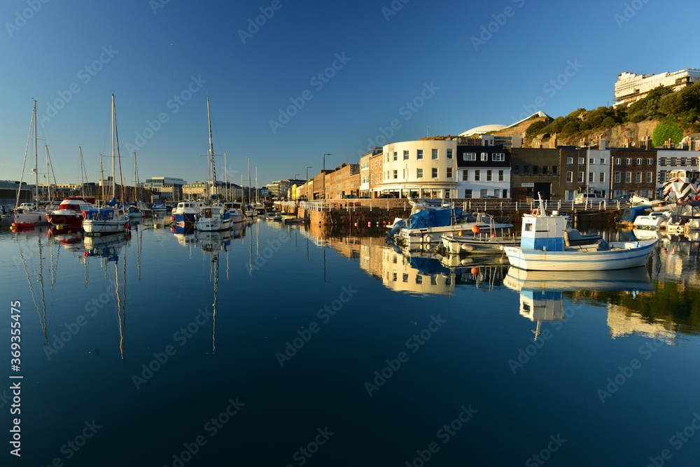 English harbour, Jersey, U.K. Summer evening calm high tide at a 19th century commercial dock.