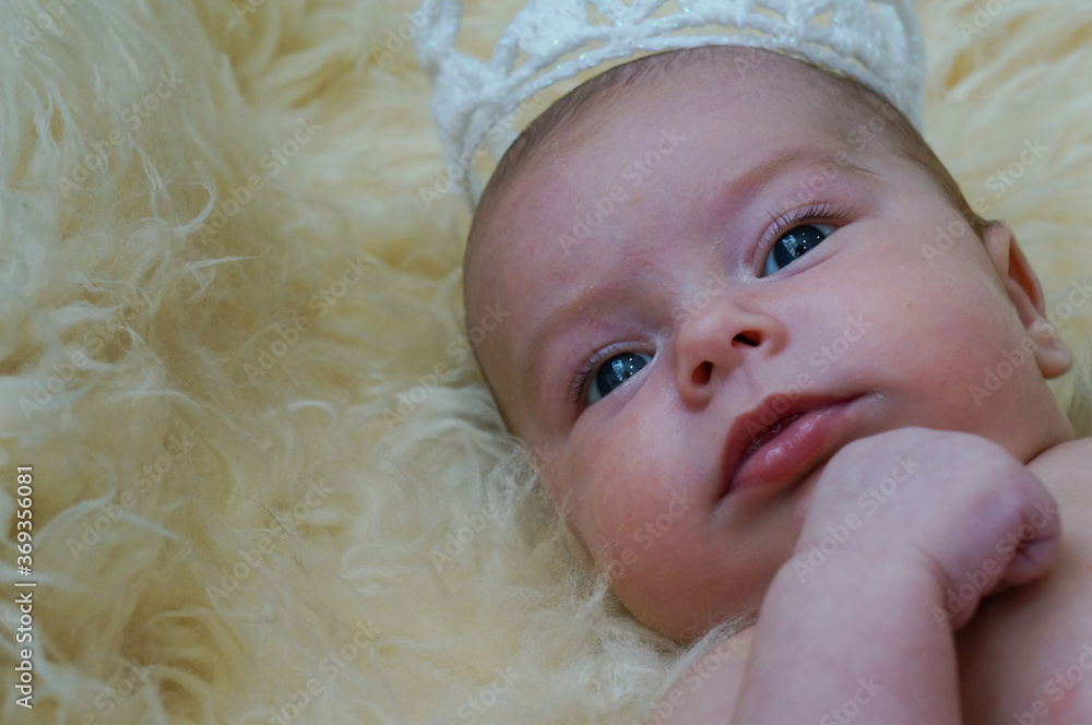 Portrait of a cute newborn baby girl with white knitted crown Portrait of a cute newborn baby girl with white knitted crown