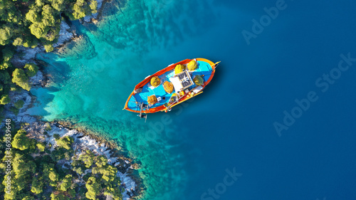 Aerial drone top down photo of traditional fishing boat anchored near small picturesque port of Agnontas, Skopelos, Sporades, Greece