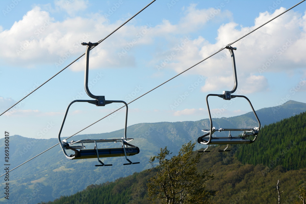 Old Mountain, Serbia, July 28, 2020, Empty ski lift chairs sitting idle during the summer. Waiting for snow. Old Mountain, Serbia, July 28, 2020, Empty ski lift chairs sitting idle during the summer. Waiting for snow.
