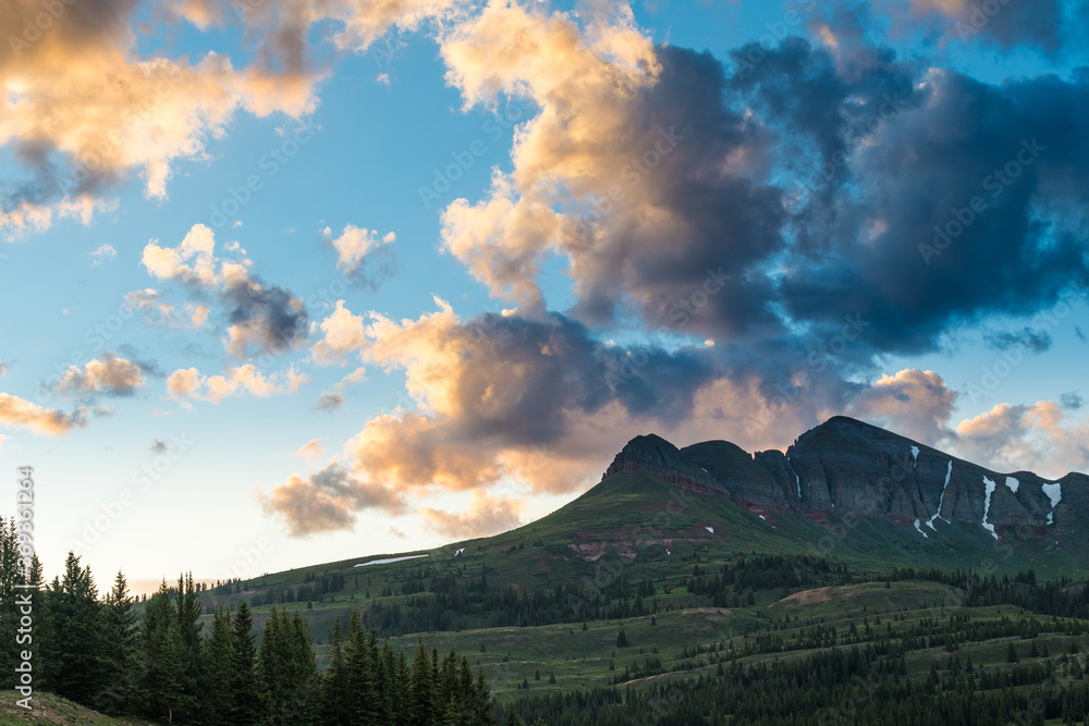 Dramatic, colorful clouds and sky at sunset over a snow-capped mountain in the Molas Pass along the Million Dollar Highway in Colorado