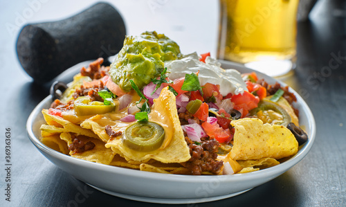 plate of loaded nachos with queso cheese photo