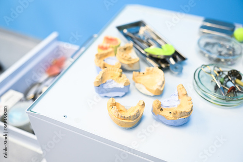 Different professional dental equipment, instruments and tools in a dentists stomatology office clinic on a white background. Silicone cast of the jaw.