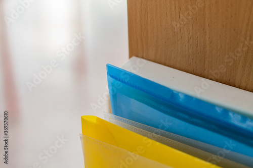 Colored folders are on the shelf. Organization of documents.