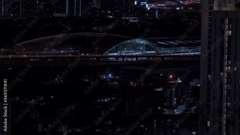 High angle view cityscape of futuristic skyscraper and busy traffic driving car on the road and highway with business financial building and illuminated city street night lights at downtown district. High angle view cityscape of futuristic skyscraper and busy traffic driving car on the road and highway with business financial building and illuminated city street night lights at downtown district.