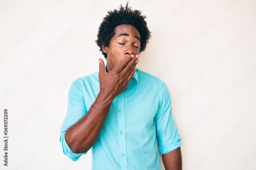 Handsome african american man with afro hair wearing casual clothes bored yawning tired covering mouth with hand. restless and sleepiness. Handsome african american man with afro hair wearing casual clothes bored yawning tired covering mouth with hand. restless and sleepiness.