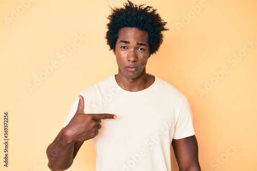 Handsome african american man with afro hair pointing with fingers to himself depressed and worry for distress, crying angry and afraid. sad expression.