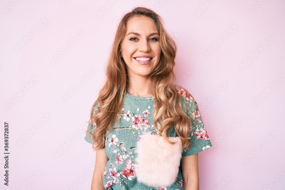 Young caucasian woman with blond hair wearing casual clothes looking positive and happy standing and smiling with a confident smile showing teeth Young caucasian woman with blond hair wearing casual clothes looking positive and happy standing and smiling with a confident smile showing teeth