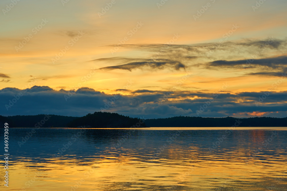 Fototapeta premium A colofrul sunset with reflections on water in an archipelago in Parainen, Finland.