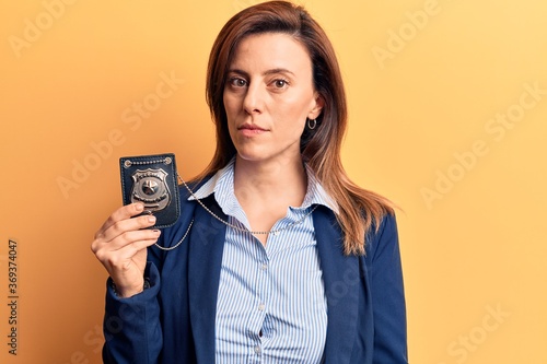 Photos Young beautiful woman holding detective badge thinking attitude and sober expres