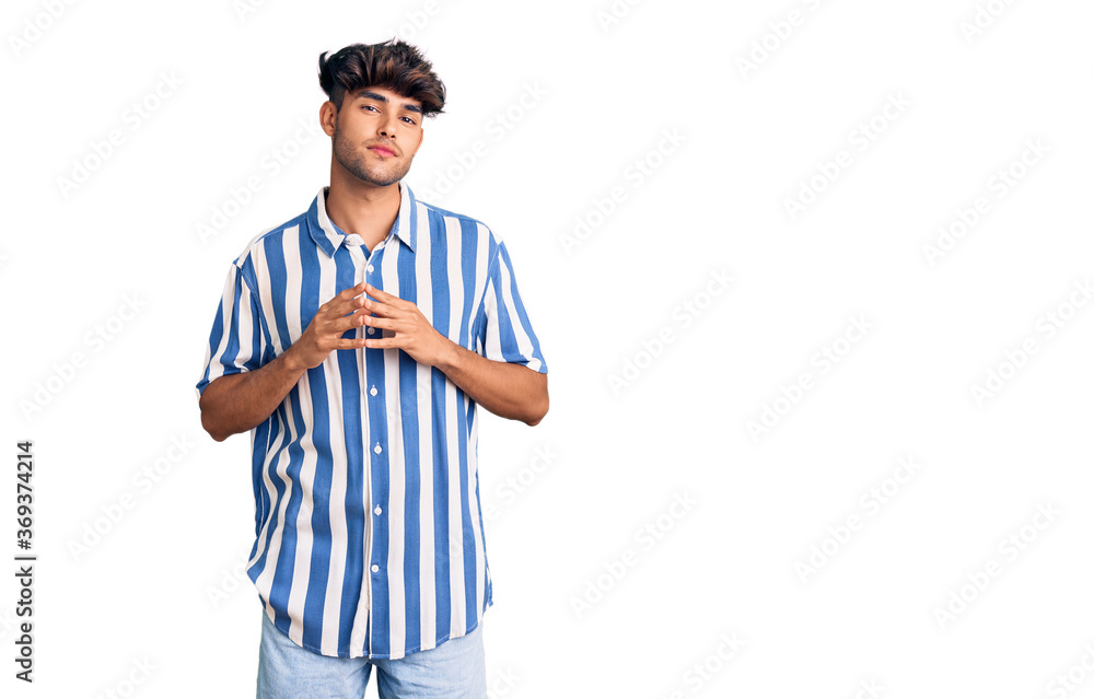 Young hispanic man wearing casual clothes hands together and fingers crossed smiling relaxed and cheerful. success and optimistic Young hispanic man wearing casual clothes hands together and fingers crossed smiling relaxed and cheerful. success and optimistic