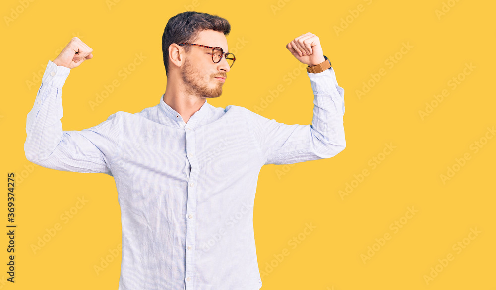 Handsome young man with bear wearing elegant business shirt and glasses showing arms muscles smiling proud. fitness concept. Handsome young man with bear wearing elegant business shirt and glasses showing arms muscles smiling proud. fitness concept.