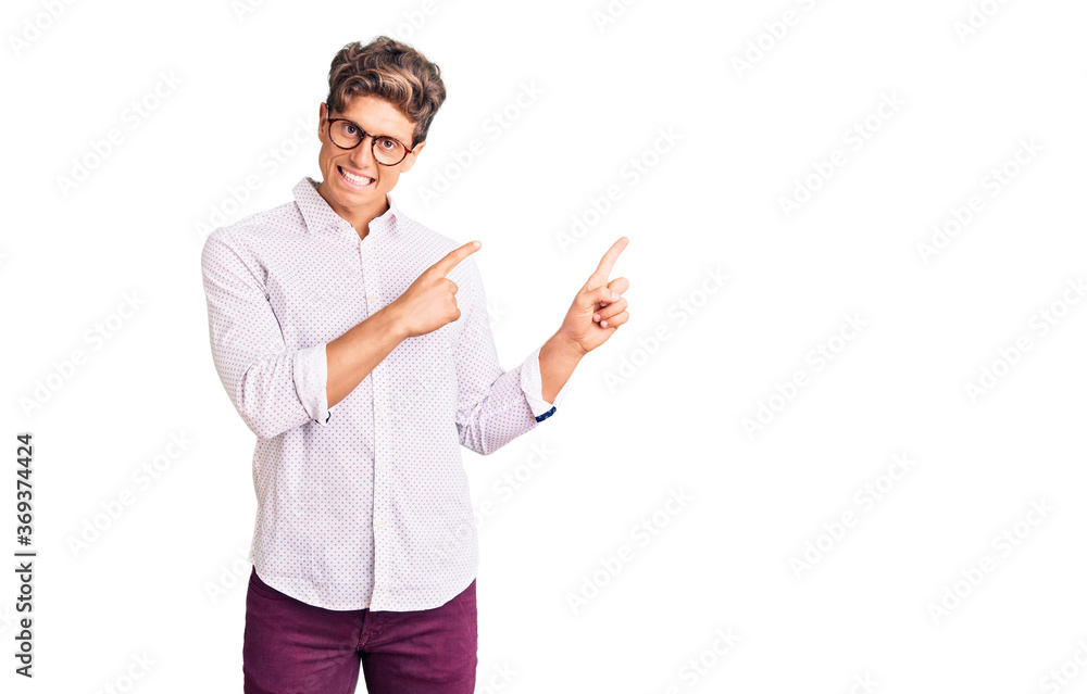 Young handsome man wearing business clothes and glasses smiling and looking at the camera pointing with two hands and fingers to the side. Young handsome man wearing business clothes and glasses smiling and looking at the camera pointing with two hands and fingers to the side.