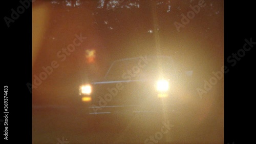 Retro / Vintage / Classic 1970s pickup truck enters frame and shines headlights at camera / shot on Super 8 film