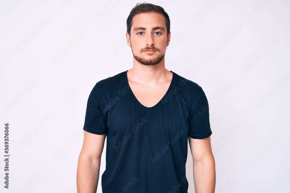 Young handsome man wearing casual clothes with serious expression on face. simple and natural looking at the camera. Young handsome man wearing casual clothes with serious expression on face. simple and natural looking at the camera.