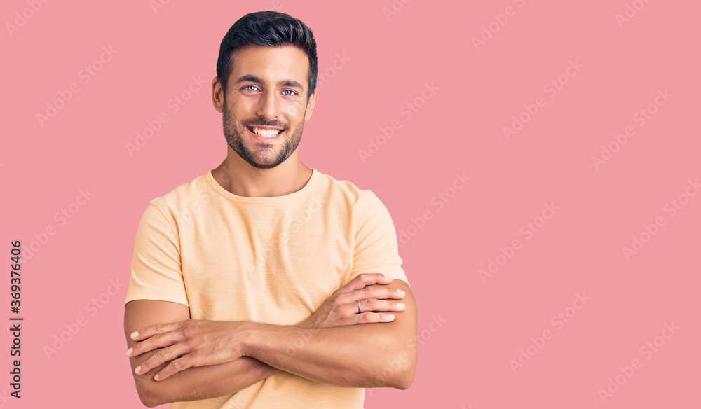 Young hispanic man wearing casual clothes happy face smiling with crossed arms looking at the camera. positive person. Young hispanic man wearing casual clothes happy face smiling with crossed arms looking at the camera. positive person.